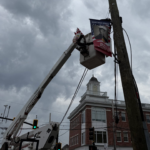 bucket truck installing pole banner